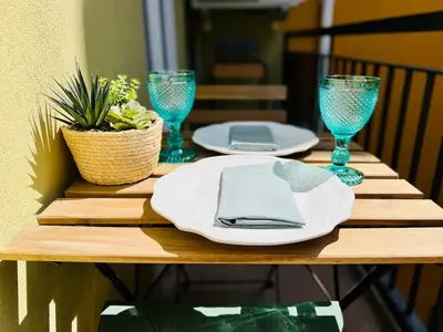 a wooden table with plates and wine glasses on it at The Green House - Oporto Charming Apartment in Porto