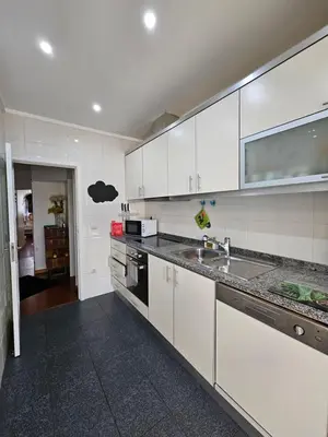 a kitchen with white cabinets and a sink at Porto Central Terrace Apartment in Porto