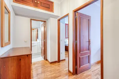 a hallway with a wooden door and a mirror at OPORTO GUEST Lobo Flat with Parking in Porto