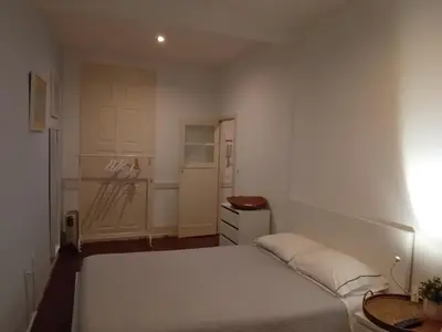 a bedroom with a white bed and a door at Oupas 2 Lofts in Porto