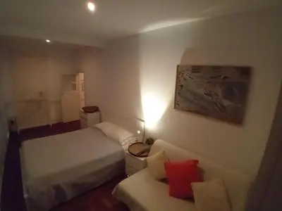 a small bedroom with a bed and a couch at Oupas 2 Lofts in Porto
