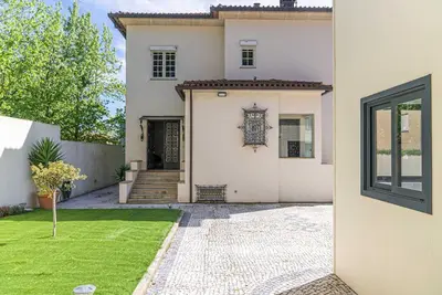 a white house with a gate and a yard at The Porto Villa in Porto