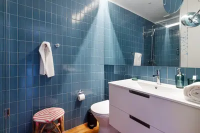 a blue tiled bathroom with a toilet and a sink at Stylish Loft in the city centre in Porto