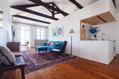 a living room with a blue couch and a rug at Stylish Loft in the city centre in Porto