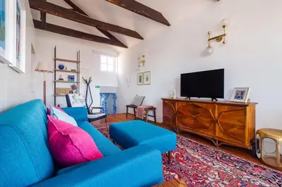 a living room with a blue couch and a flat screen tv at Stylish Loft in the city centre in Porto