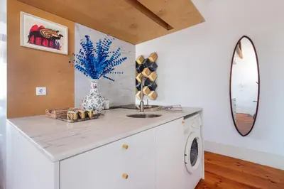 a kitchen with a counter with a sink and a mirror at Stylish Loft in the city centre in Porto