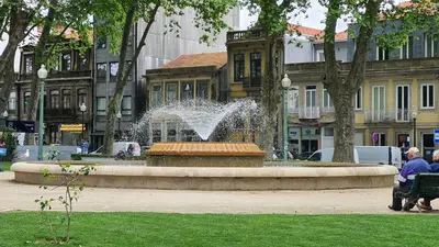 a fountain in a park with a person sitting on a bench at Bedroom with private bathroom in the city center, next to the subway in Porto