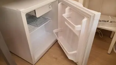 a white refrigerator with its door open in a kitchen at Bedroom with private bathroom in the city center, next to the subway in Porto