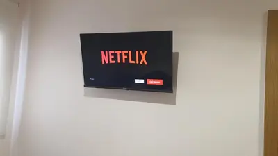 a television with the netflix sign on a wall at Bedroom with private bathroom in the city center, next to the subway in Porto