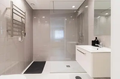 a white bathroom with a shower and a sink at T2 Constituição in Porto