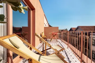 a balcony with chairs and a table on a building at Trendy & Charming Apartment • Porto city center in Porto