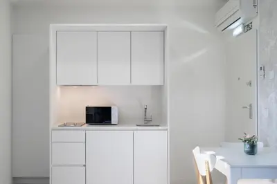 a kitchen with white cabinets and a microwave on a counter at Host Wise - Central Private Flats - Terrace in Porto
