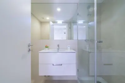 a white bathroom with a sink and a shower at Host Wise - Central Private Flats - Terrace in Porto
