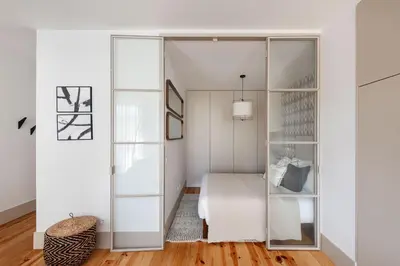 a bedroom with a white bed and a glass closet at Stylish apartment in city center in Porto