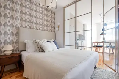 a bedroom with a large white bed and a large window at Stylish apartment in city center in Porto