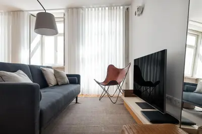 a living room with a blue couch and a chair at Stylish apartment in city center in Porto
