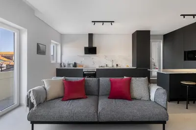 a living room with a couch with two red pillows at WHome Prime Portal to Porto Your Gateway to Urban Wonders in Porto