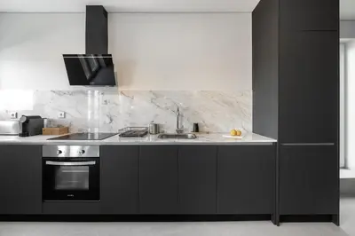 a kitchen with black cabinets and a sink at WHome Prime Portal to Porto Your Gateway to Urban Wonders in Porto