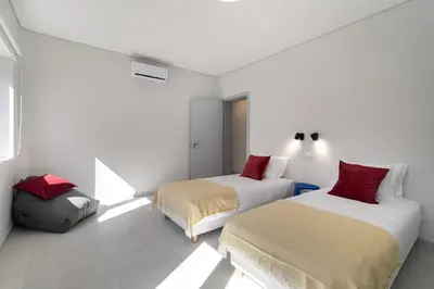 two beds in a white room with red pillows at WHome Prime Portal to Porto Your Gateway to Urban Wonders in Porto