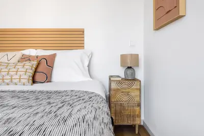 a bedroom with a bed and a night stand with a lamp at Lovely 2-bed in the city centre with a sunny balcony in Porto