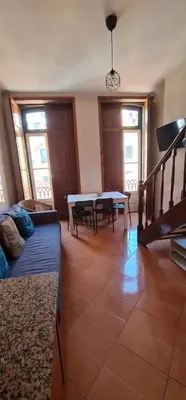 a living room with a couch and a table at Flores duplex in Porto