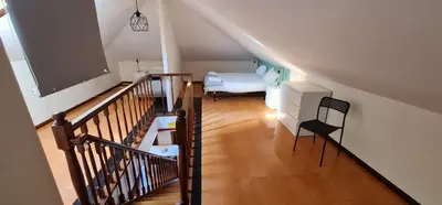 a room with a staircase with a bed and a table at Flores duplex in Porto