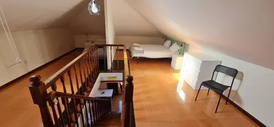 a attic room with a bed and a staircase at Flores duplex in Porto