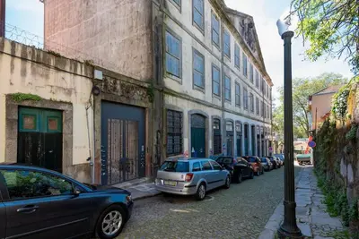 a row of cars parked on a street next to a building at Cedofeita Studio - Your Porto Escape in Porto
