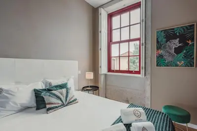 a white bathroom with a toilet and a sink at Mira Alfandega apartment in Porto