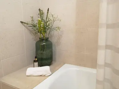 a green vase with flowers sitting on top of a bath tub at Palácio Garden's House by LovelyStay in Porto