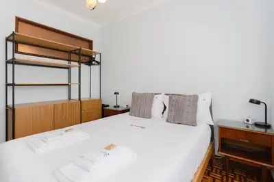 a bed with a grey blanket and pillows at Liiiving in Porto - Vintage Design Apartment in Porto