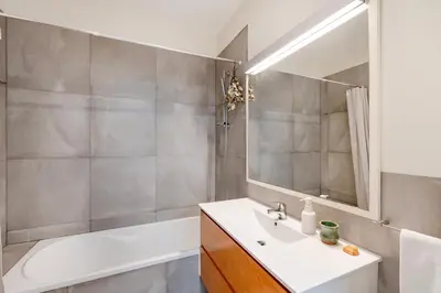 a bathroom with a sink and a tub and a mirror at VIVA Boavista Vintage House in Porto