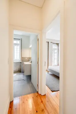 a bathroom with a sink and a bedroom with a bed at VIVA Boavista Vintage House in Porto