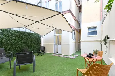 a patio with green grass and chairs and a tent at Casa Maya in Porto