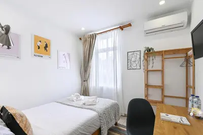 a bedroom with a bed and a desk and a window at Casa Maya in Porto