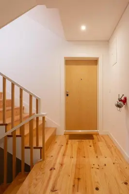 an empty room with a staircase and a wooden door at Host Wise - Modern Urban Flat in Porto