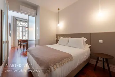 a bedroom with a large bed and a table at The Clérigos 46 in Porto