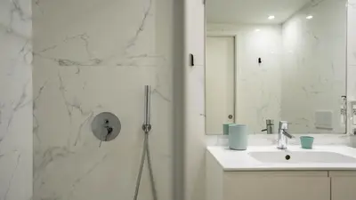 a white bathroom with a sink and a shower at Serene 1BR Spot by LovelyStay in Porto