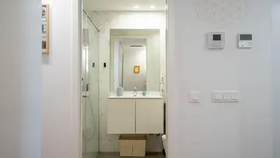 a white bathroom with a sink and a mirror at Serene 1BR Spot by LovelyStay in Porto