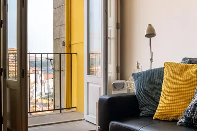 a black couch sitting in a room with a window at Merc Porto Vitoria's Place in Porto