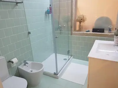 a bathroom with a shower and a toilet and a sink at Merc Porto Vitoria's Place in Porto