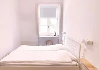 a bed in a white room with a window at Hostel Alegria in Porto