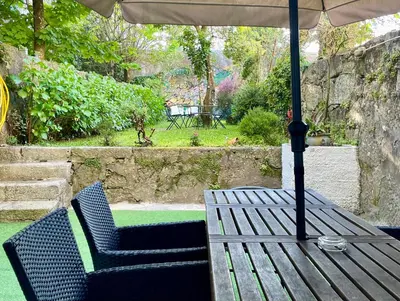 a wooden table with two chairs and an umbrella at Hostel Alegria in Porto