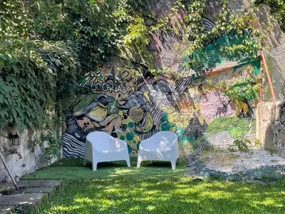two white chairs in front of a wall with graffiti at Hostel Alegria in Porto