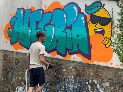 a man standing in front of a wall with graffiti at Hostel Alegria in Porto