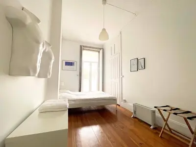 a white room with a bed and a window at Hostel Alegria in Porto