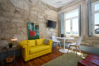 a living room with a yellow couch and a table at Live In Porto - Codeçal in Porto