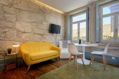 a living room with a yellow couch and a table at Live In Porto - Codeçal in Porto