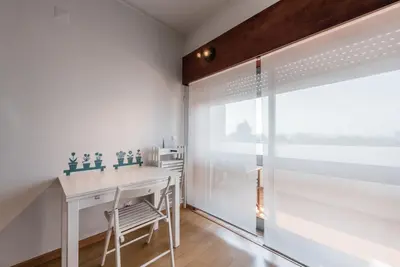 a dining room with a white table and a large window at GuestReady - Urban escape with a view in Porto