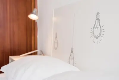 a bedroom with a white bed and a light at GuestReady - Urban escape with a view in Porto